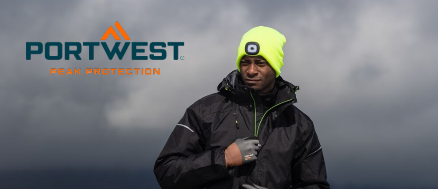 Bild eines Arbeiters in schwarzer Arbeitskleidung. Der Mann tr&auml;gt Handschuhe und eine gelbe M&uuml;tze mit eingebauter LED-Lampe. Im Hintergrund sieht man dunkle Wolken und eine nebelverhangene Landschaft.