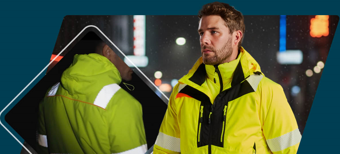 Ein Arbeiter in gelber Warnschutzkleidung mit Reflexstreifen und schwarzen Details. Im Hintergrund sieht man einen dunklen Stra&szlig;enzug mit verschwommene Beleuchtung. Links im Bild ist die R&uuml;ckenansicht der Jacke dargestellt.