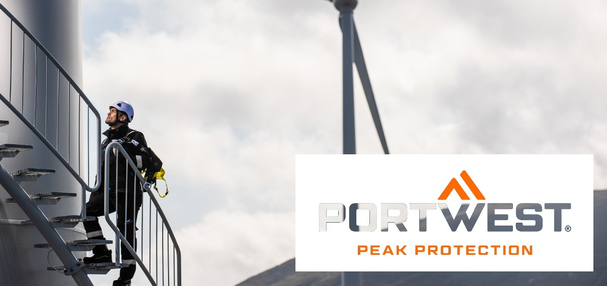 Arbeiter in Schutzkleidung, der ein Windrand über eine Wendeltreppe besteigt. Im Hintergrund sieht man graue Wolken, Berge und ein weiteres Windrad. Im rechten unteren Bildrand befindet sich das Logo von Portwest in Weiß und Orange.