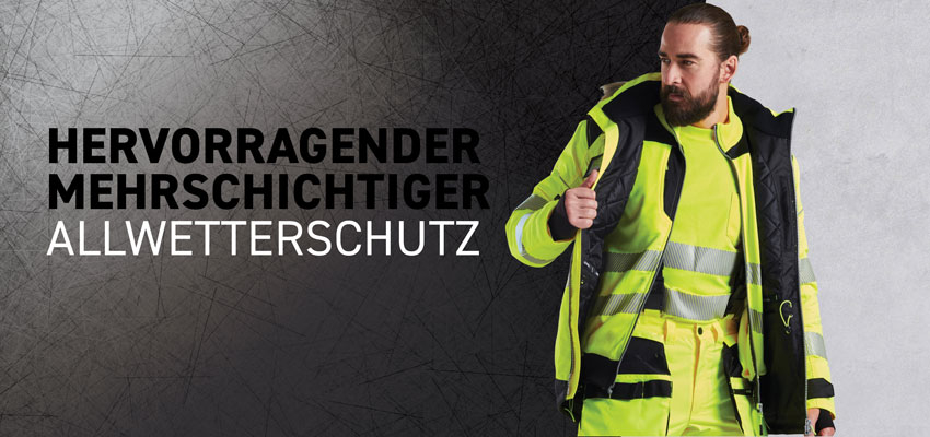 Bärtiger Mann in mehrschichtiger Allwetter-Warnschutzkleidung.