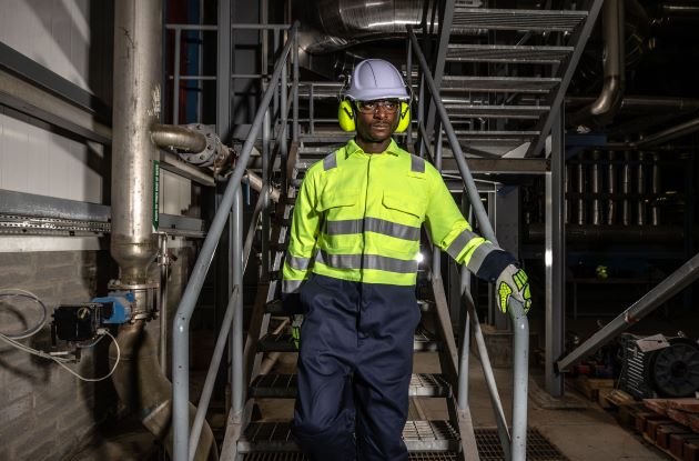 Arbeiter in Hi-Vis Kleidung der eine Treppe hinunter läuft