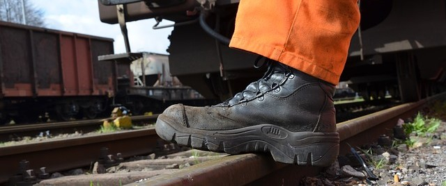 Arbeiter mit Warnhose in Orange und Arbeitsschuhen.